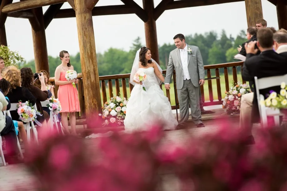 Bride and groom walking from the waterfront gazebo at Solitude Links